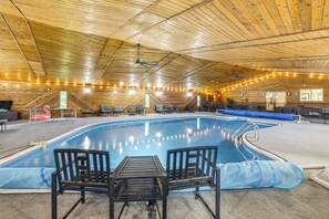 An indoor swimming pool with a wooden ceiling and seating area. - Featured on TV! Epic Indoor Pool Sleeps 24 (Bridgman)