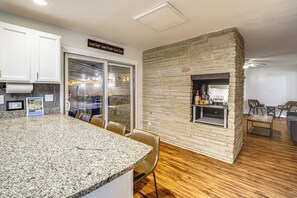 Una cocina moderna con encimeras de granito, protector contra salpicaduras de piedra y una parrilla empotrada.
