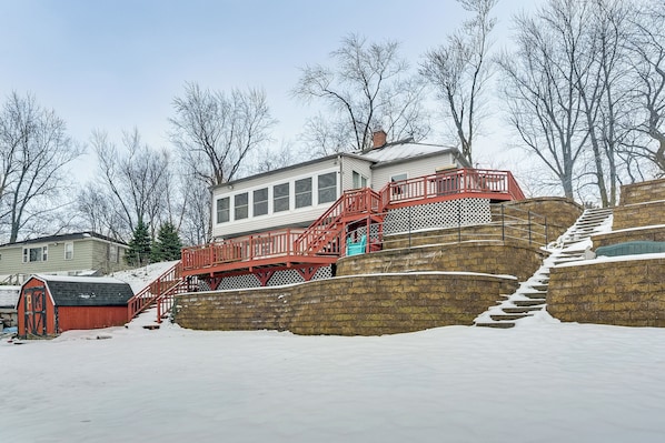 Ein Haus mit einer roten Freitreppe, umgeben von Schnee.