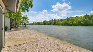 A lakeside property with a patio, a concrete deck, and a view of the lake and forest. - On-site Boat Launch! Lakefront Hot Springs Cabin (Hot Springs)