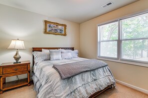 A bedroom with a bed, nightstand, lamp, window, and a framed picture on the wall. - Private Dock! High Rock Lake Getaway in Lexington (Lexington)