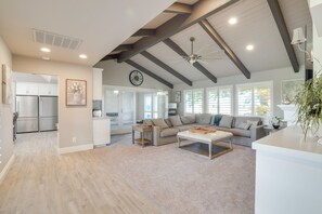 A spacious living area with a high ceiling, a large sofa, a coffee table, and a kitchen in the background. - Poolside Escape w/ Hot Tub! 8 Mi to Dtwn Modesto (Ripon)