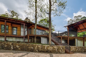 A two-story wooden house with a stone foundation, a balcony, and a staircase. - Grand Lake Group Getaway w/ Dock & Spacious Deck (Eucha)