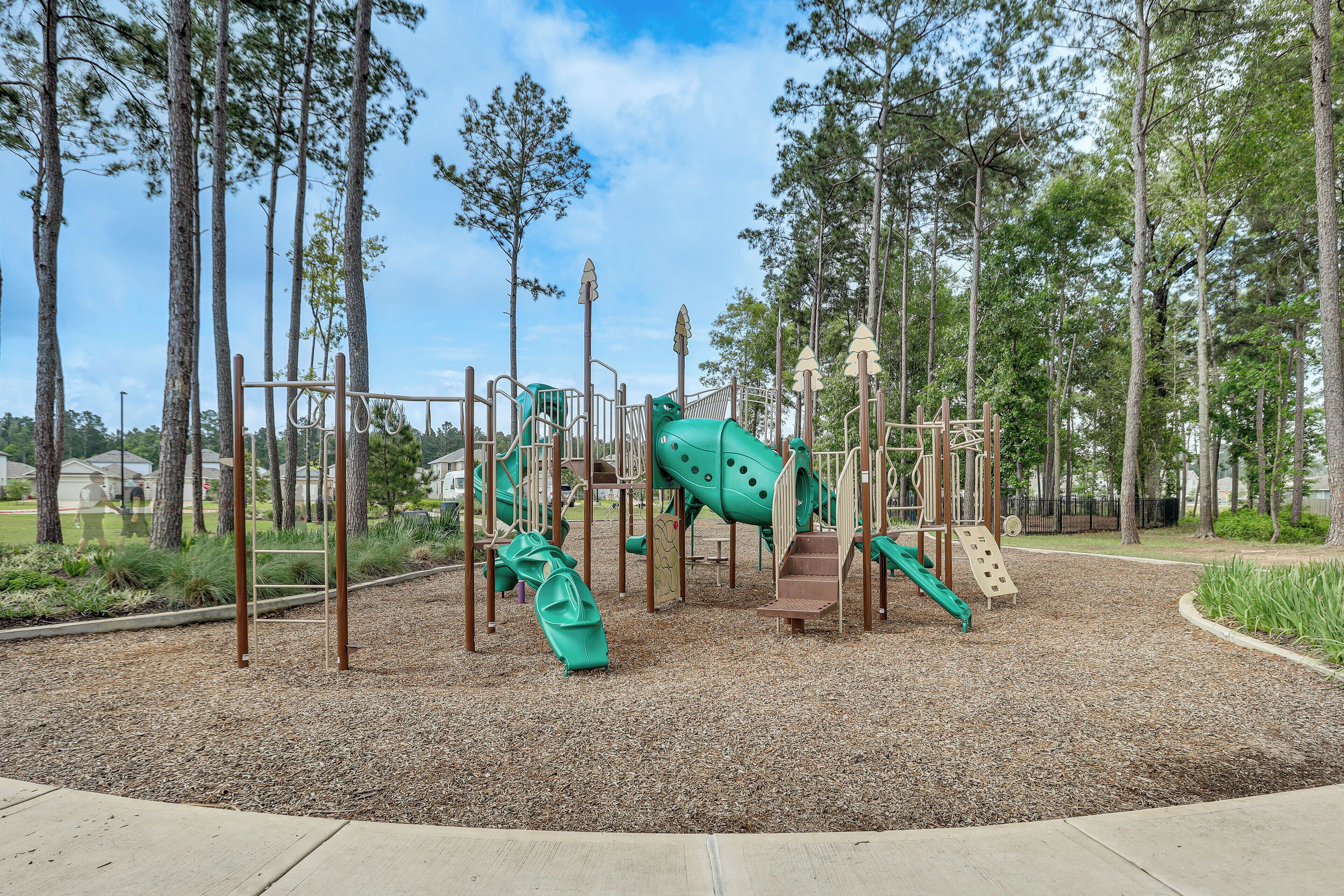 A playground with climbing structures, slides, and a rubberized surface.
