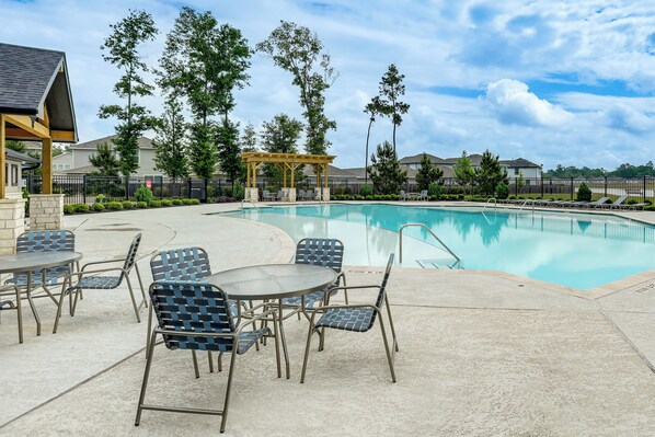 Une piscine avec des chaises longues et un espace de repos abrité.