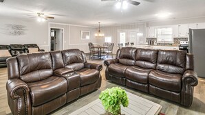 A spacious living room with two leather sofas, a dining area, and a kitchen in the background. - 2 Mi to Dtwn Vidalia! Pet-friendly Retreat w/ Yard (Vidalia)