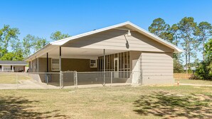 A single-story building with a covered porch, a fenced yard, and trees in the background. - 2 Mi to Dtwn Vidalia! Pet-friendly Retreat w/ Yard (Vidalia)