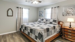 A bedroom with a bed, a ceiling fan, a nightstand, and a wall-mounted mirror. - 2 Mi to Dtwn Vidalia! Pet-friendly Retreat w/ Yard (Vidalia)