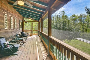 A wooden deck with outdoor seating, a view of trees, and a covered area with a ceiling fan. - Hike, Bike, Tubing, Whitewater Rafting! Saluda Gem (Saluda)