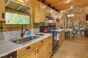 A wooden cabin interior with a kitchen featuring a sink, stove, and cabinets. - Hike, Bike, Tubing, Whitewater Rafting! Saluda Gem (Saluda)