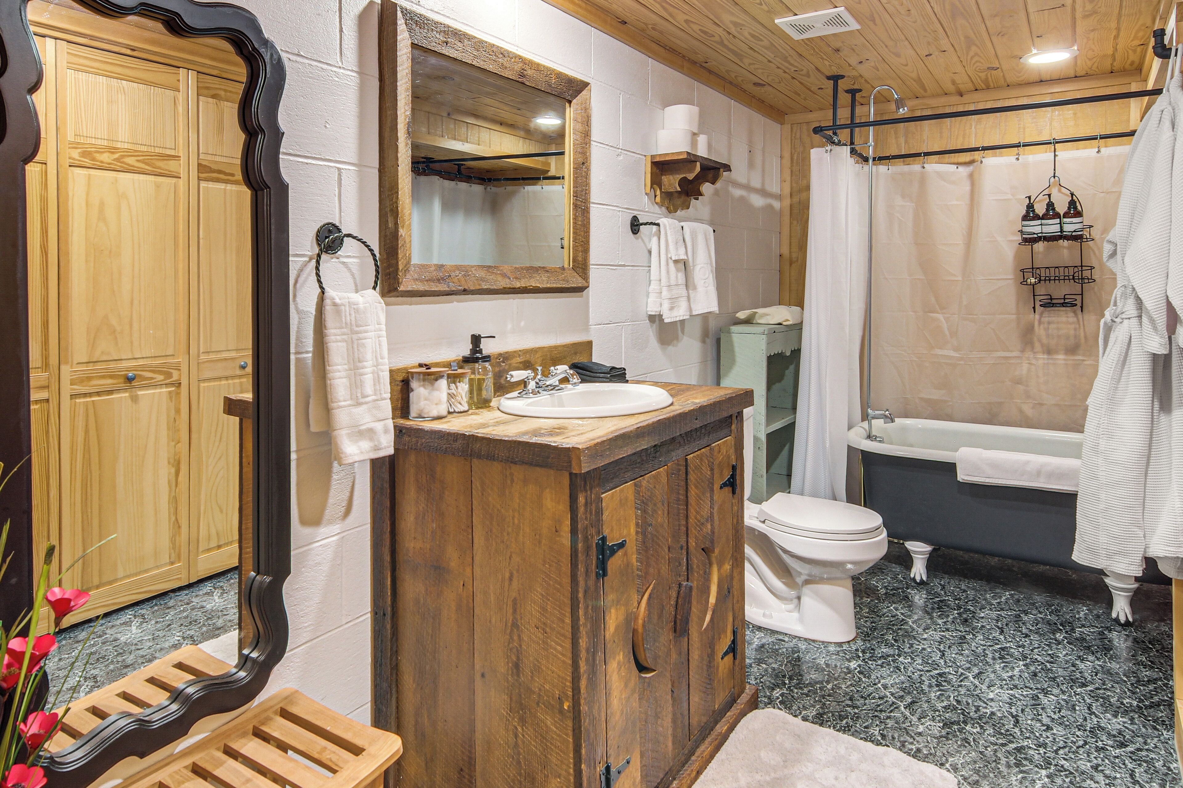 Ein Badezimmer mit einem Holzwaschtisch, einem Waschbecken, einer Toilette, einer Badewanne und einer Duschvorhang.