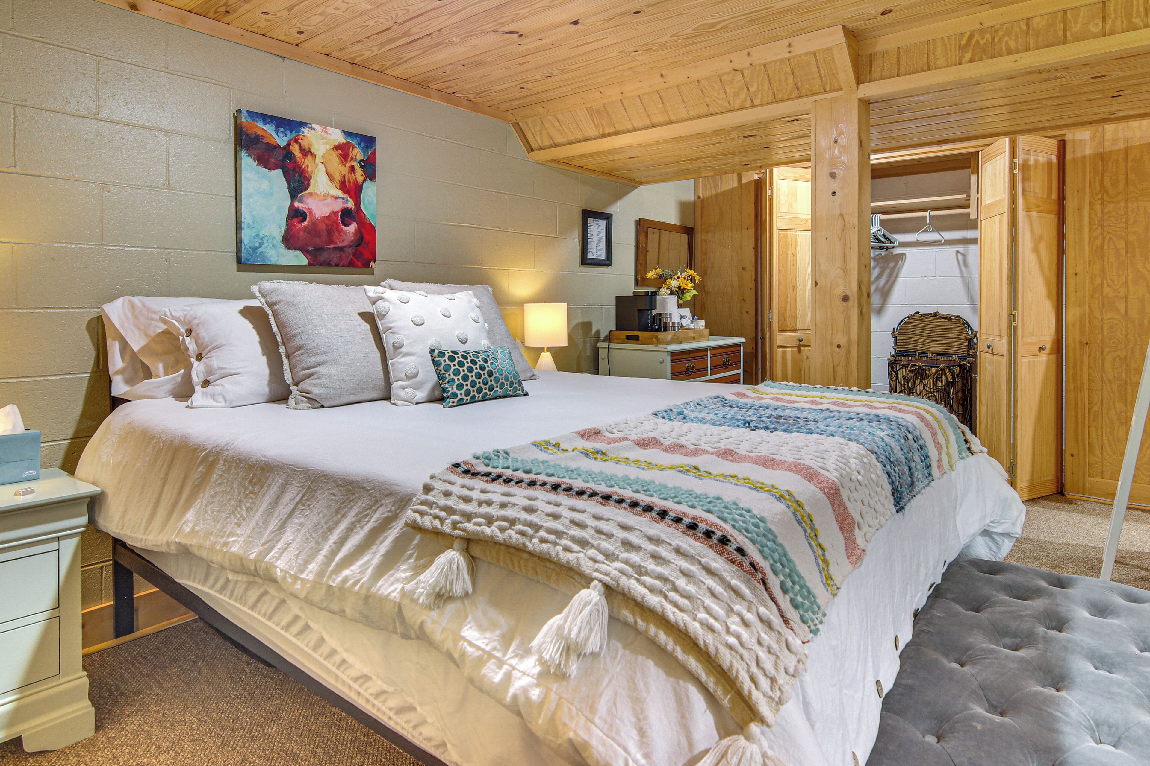 Une chambre à coucher avec un grand lit, une table de chevet, une commode, un miroir et une armoire.