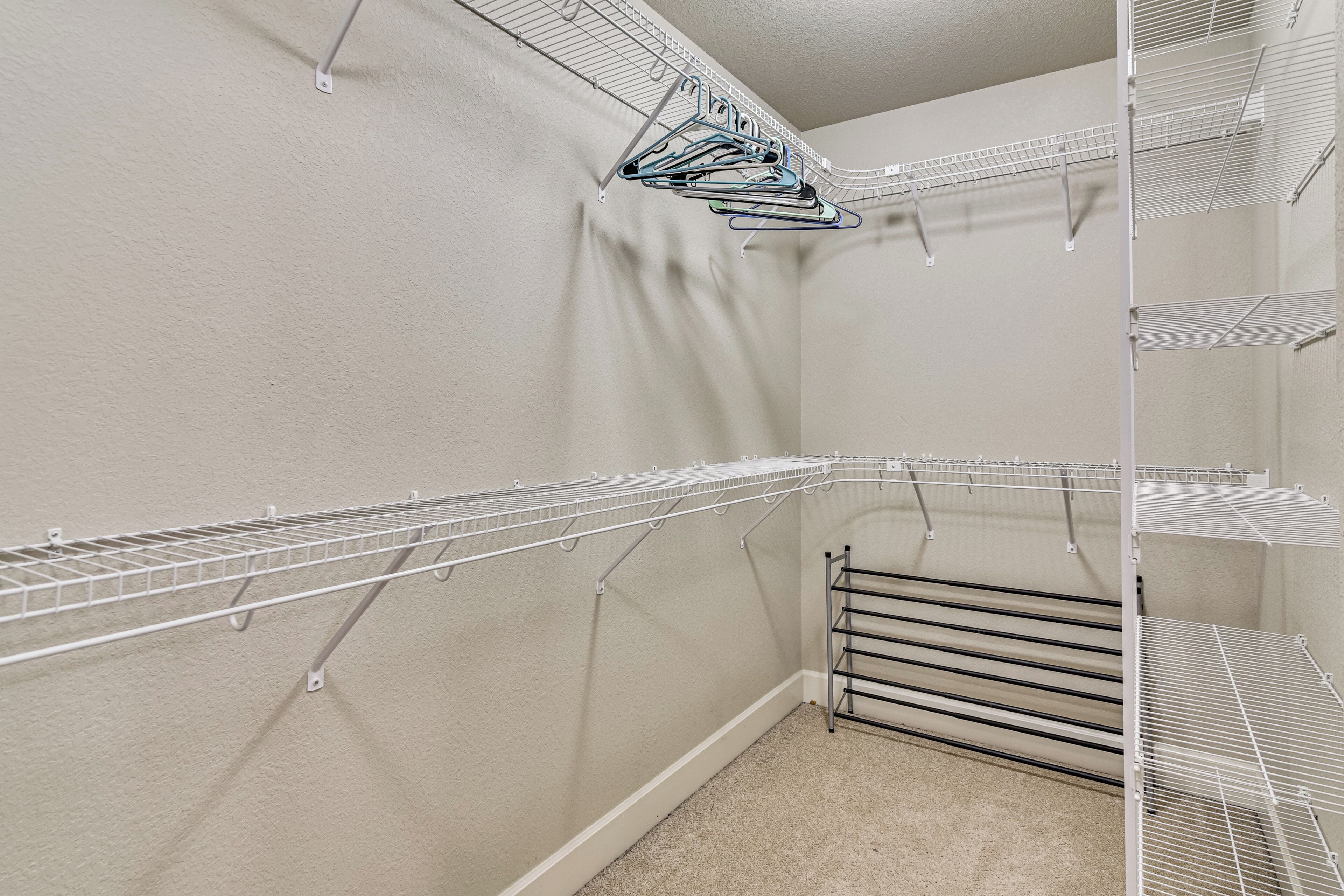 A storage closet with metal shelves and a metal drying rack.