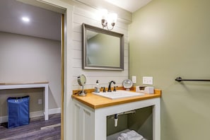 A bathroom with a sink, mirror, and towel rack. - Beachfront Bliss on Newfound Lake! Bristol Condo (Bristol)