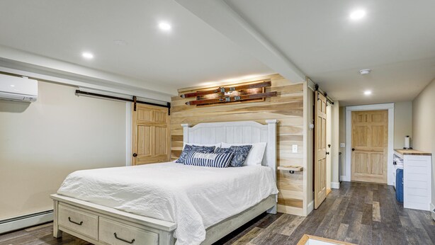 Ein Schlafzimmer mit einem Bett, einem Holzkopfende und einem Einbauschrank darüber.
