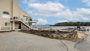 Ein Gebäude mit Balkon, Treppe und einem Steg, der ins Wasser führt.