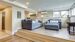 Ein Wohnzimmer mit zwei grauen Sofas, einem Holztisch und einer Treppe zu einer weiteren Ebene.