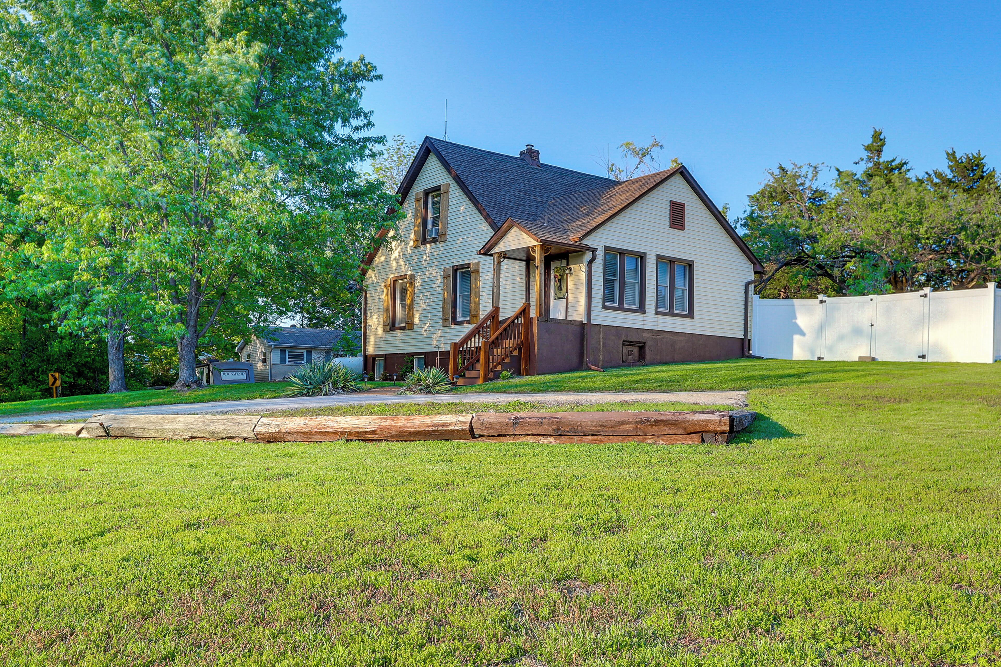 A two-story house with a front porch, a visible garage, and a well-maintained lawn.