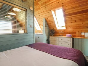A room with a bed, a dresser, a fan, and a skylight. - Skylark (Loughborough)