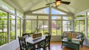 A conservatory with a dining table, chairs, a sofa, and a ceiling fan. - Historic Home w/ Hot Tub and Game Room in Augusta (Augusta)