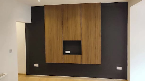 A modern room with a wooden accent wall, recessed ceiling lights, and a small built-in shelf. - 4 Bed Exeter City Center (New images coming soon) (Devon)