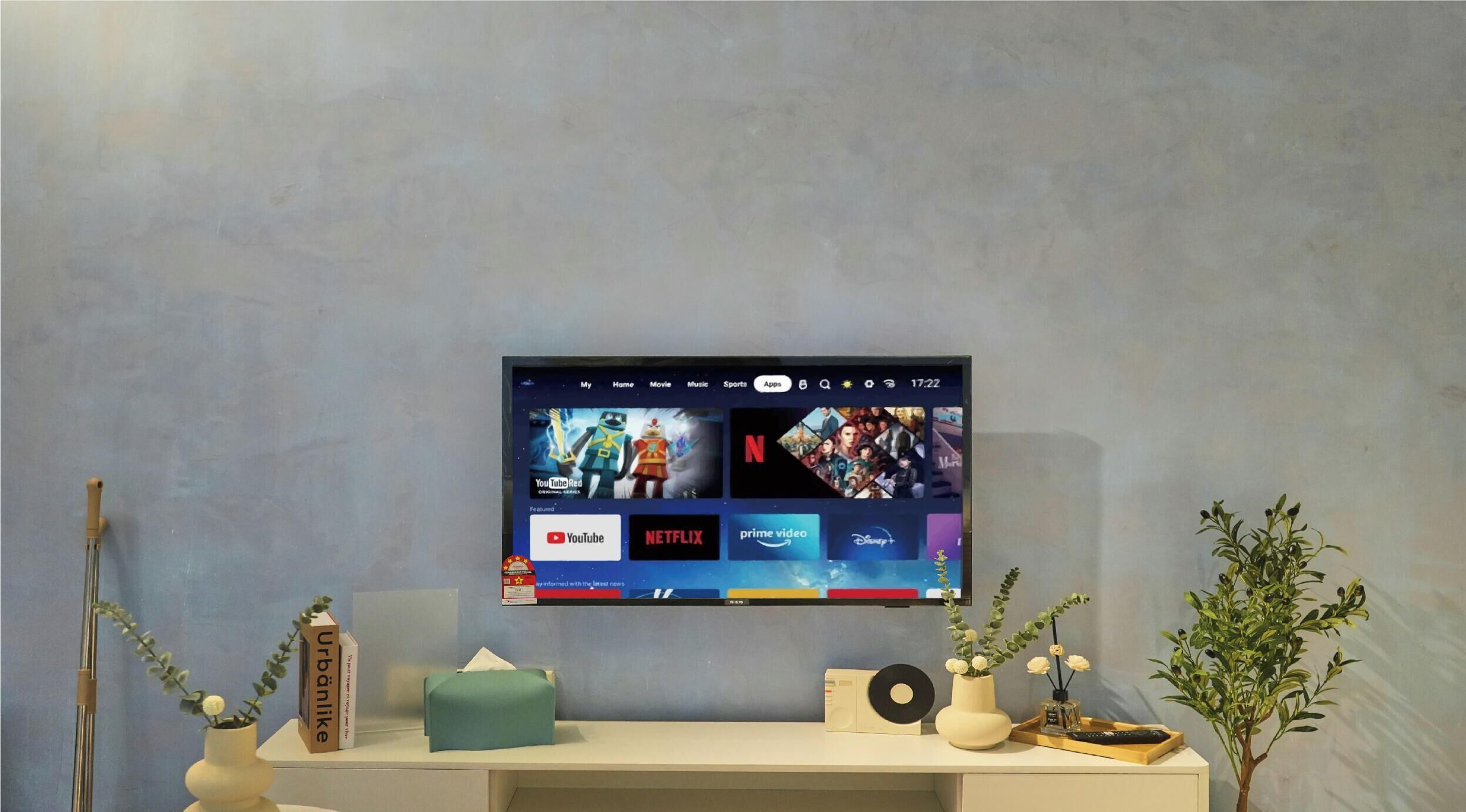 A television mounted on a wall displaying a streaming service interface with multiple app icons.