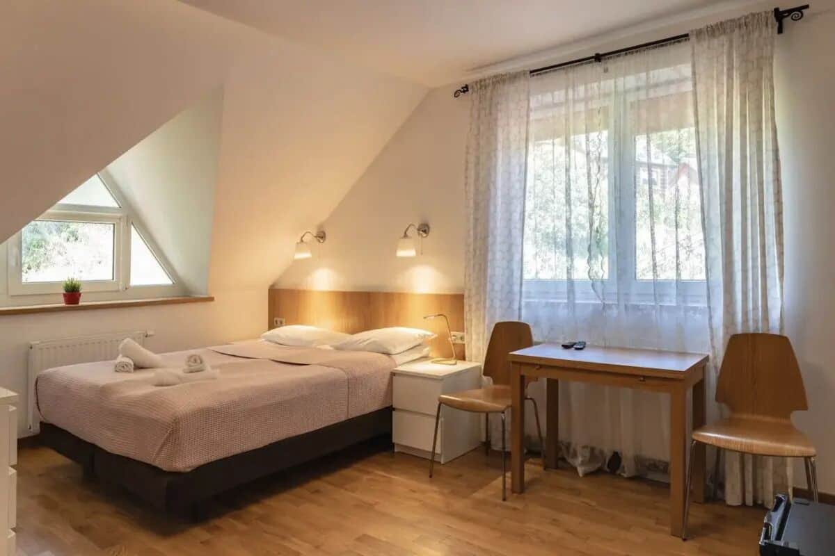 Une chambre à coucher avec un lit, des tables de chevet, un bureau et des chaises.