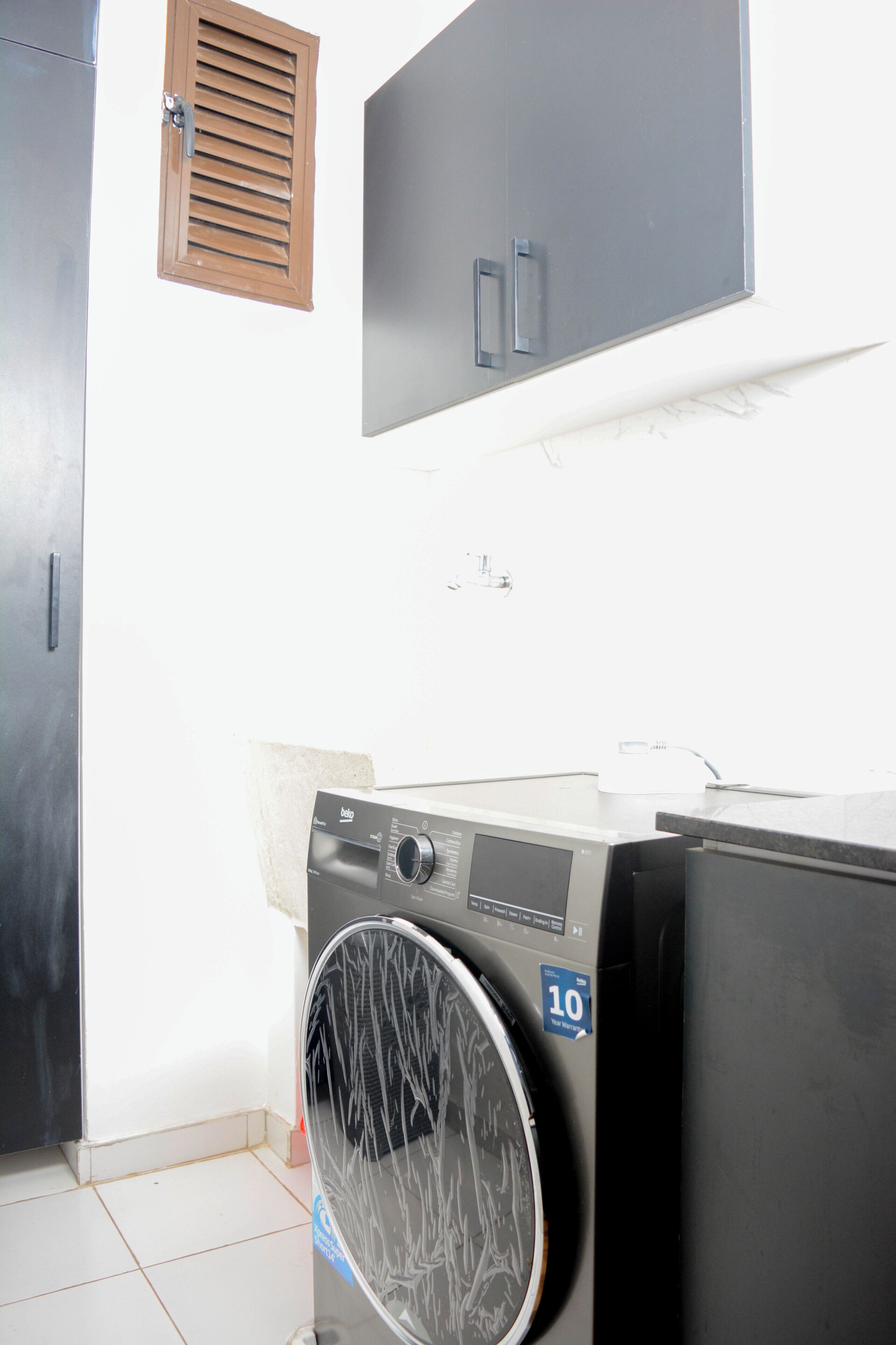 A laundry area with a washing machine, a dryer, and a cabinet.