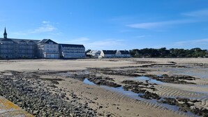 Ein Hotel direkt am Strand mit mehreren Gebäuden, einem Sandstrand und einer felsigen Küstenlinie.
