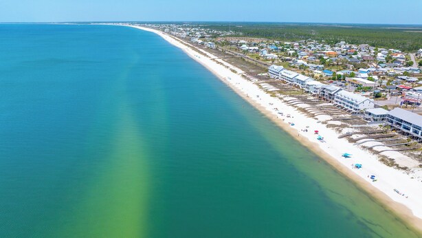 An aerial view of a coastal town with a long beach, clear water, and a mix of residential and commercial buildings. - 🏖️Steps to Beach | Great Outdoor Spaces | Perfect for Families | Beach Dreams☀️ (St. Joe Beach)