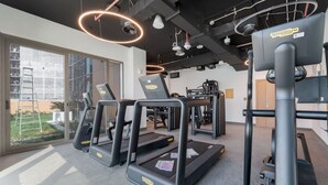 A gym with treadmills, a weight bench, and a squat rack. - Free Housekeeping Visits During Your Stay - Stayshort - Stunning 1 Bed in Maritime City That Sleeps 2 (Dubai)