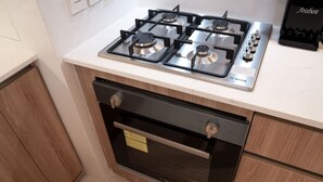 A kitchen with a Bosch gas stove, oven, and a Bosch coffee maker on the countertop. - Free Housekeeping Visits During Your Stay - Stayshort - Stunning 1 Bed in Maritime City That Sleeps 2 (Dubai)