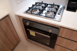 A kitchen with a Bosch gas stove, oven, and a Bosch coffee maker on the countertop. - Free Housekeeping Visits During Your Stay - Stayshort - Stunning 1 Bed in Maritime City That Sleeps 2 (Dubai)