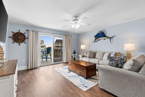 Ein Wohnzimmer mit einer Couch, einem Couchtisch und einem Deckenventilator.