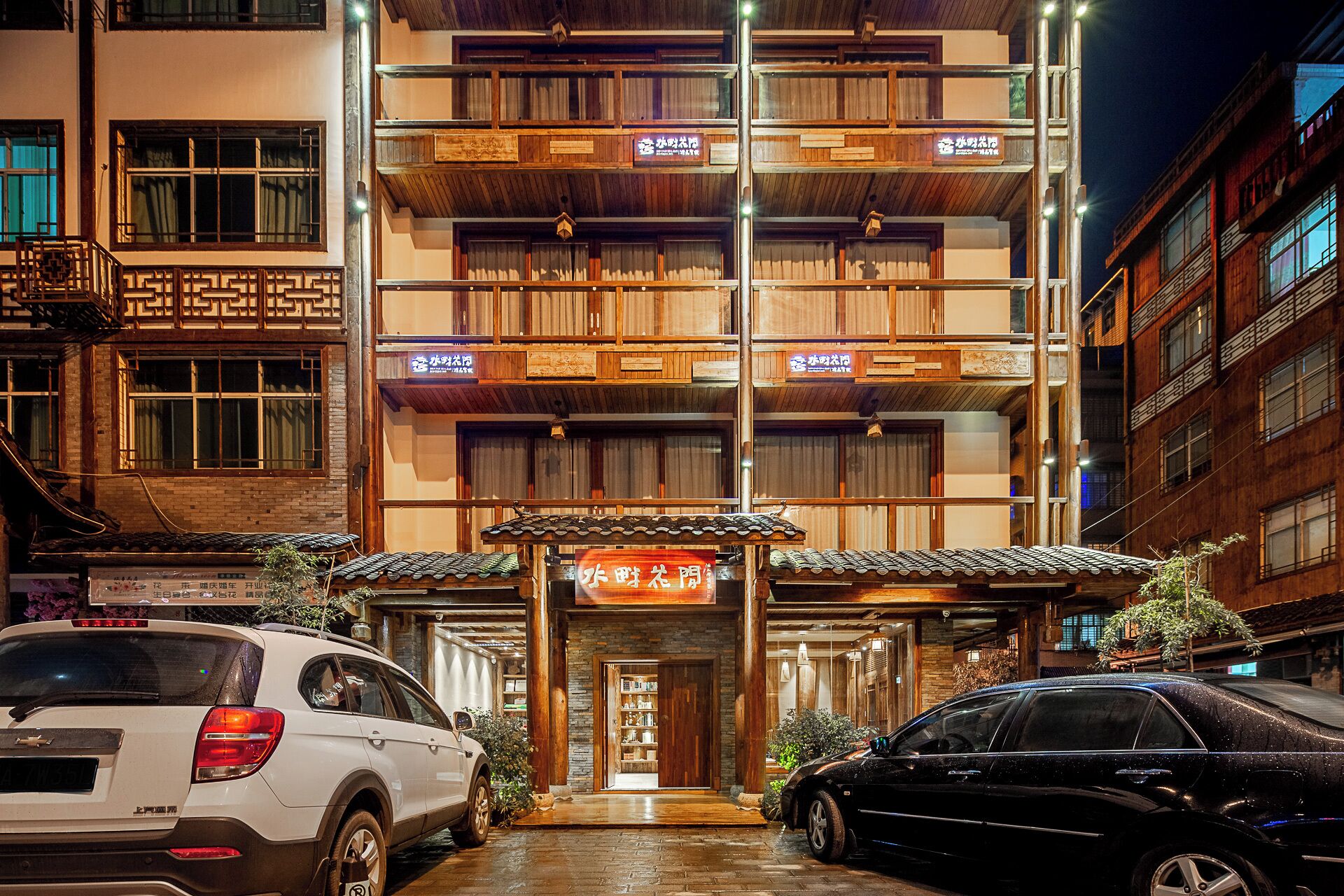 A multi-story building with a traditional architectural style, featuring wooden balconies and signage.