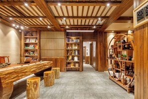 A wooden interior with a long table, bookshelves, and a staircase. - Zhangjiajie Waterfront Huajian Inn (Zhangjiajie)