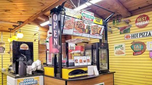 A pizza kiosk with a menu board, a cash register, and a sign that says 'OPEN'. - Elkhart RV Resort (Granger)