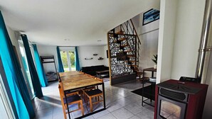 Una cocina moderna con una mesa de madera, estufa integrada y un separador decorativo.