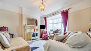 A living room with a fireplace, a television, and a sofa. - Ambleside Cottage with free private parking (Ambleside)