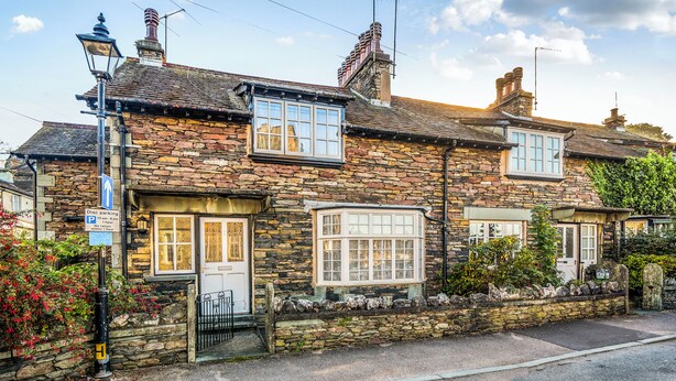 A stone building with multiple windows, a door, and a street lamp. - Ambleside Cottage with free private parking (Ambleside)