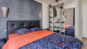 A bedroom with a bed, a wardrobe, and a mirror.