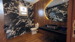 Een badkamer met toilet, wastafel en spiegel.
