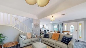 A spacious living area with a sofa set, a coffee table, and a staircase leading to an upper floor. - 3BR Beach Getaway w Balcony (Cape Canaveral)