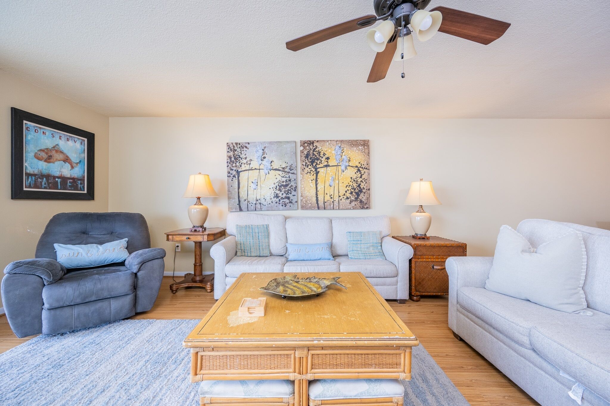 A living room with a sofa, armchair, coffee table, and two side tables with lamps.