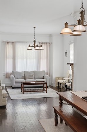 Una sala de estar con sofá, mesa de centro y banco de madera.