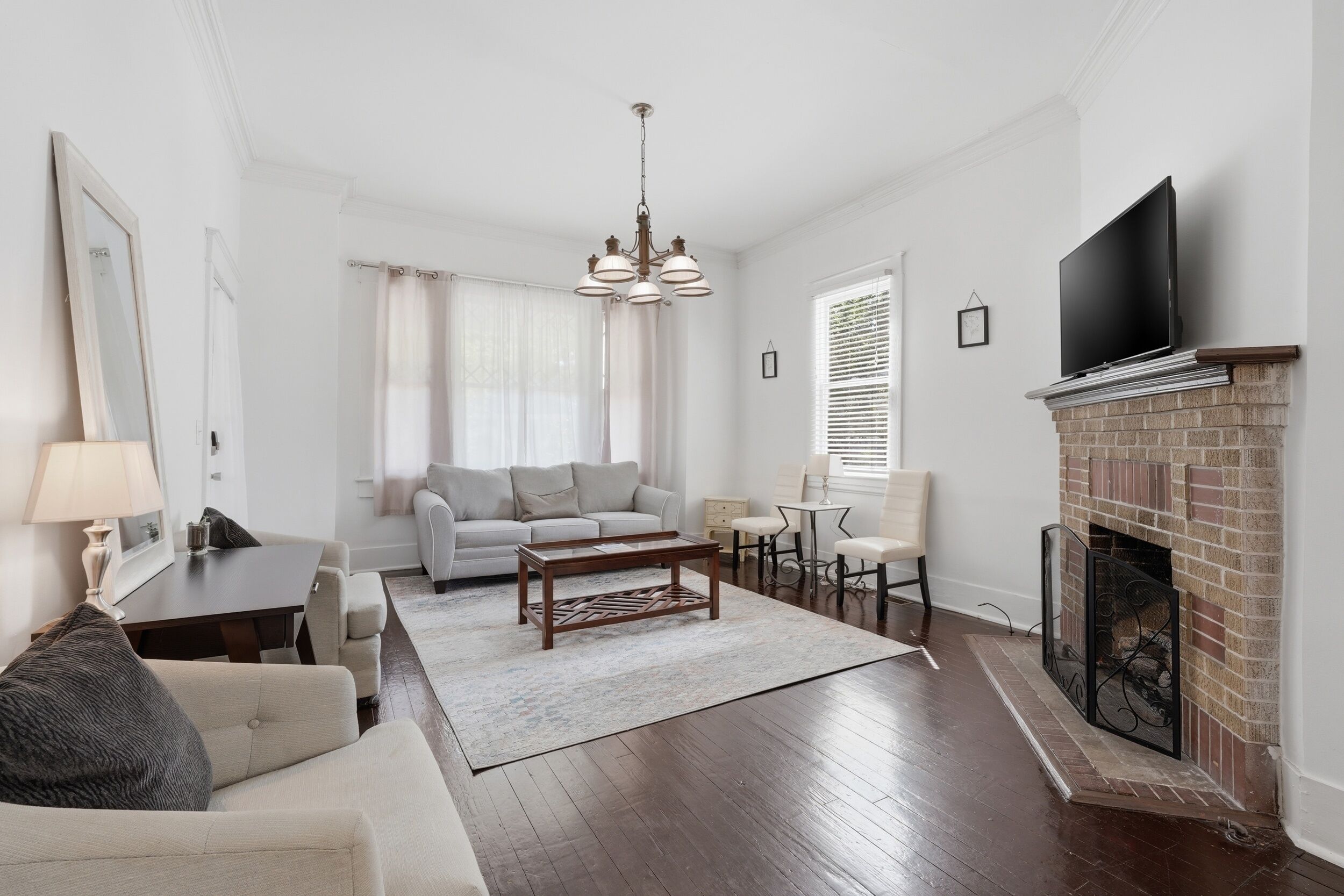 A living room with a fireplace, a sofa, a coffee table, and a TV.