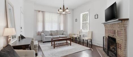 A living room with a fireplace, a sofa, a coffee table, and a TV.
