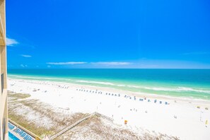 Une vue sur la plage, avec un ciel dégagé, une plage de sable et un espace piscine.