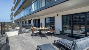 Terrassa al terrat amb taula de dinar, cadires i seients per relaxar-se.