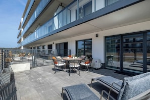 A rooftop terrace with a dining table, chairs, and lounge seating. - Stylish Apartment with Pool | Close to the Beach (Dziwnów)